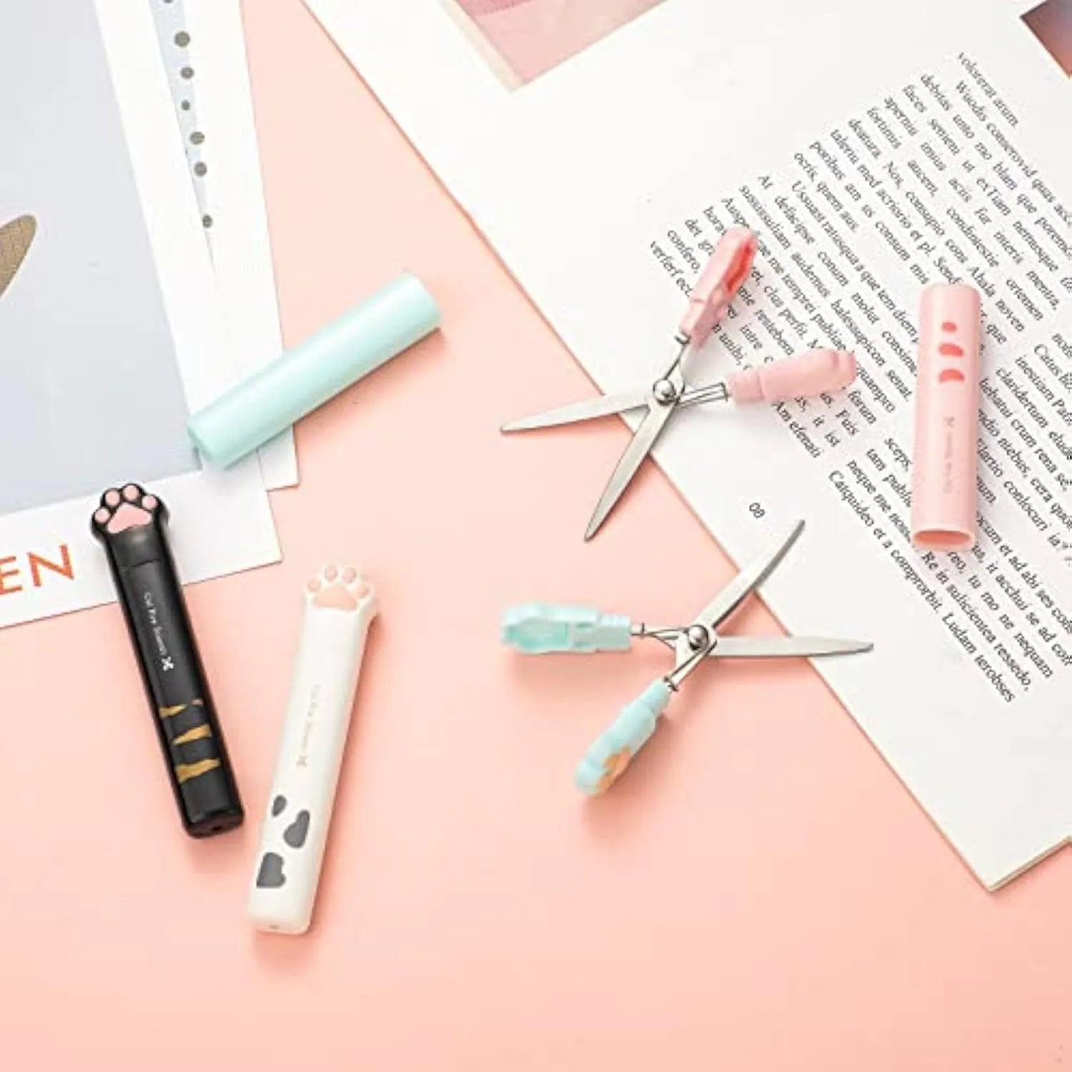 Closed cat paw mini folding scissors showing stainless steel blades and coloured handles.