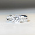 Geometric silver moissanite ring with twisted band and 1 karat centre stone in four-claw setting
