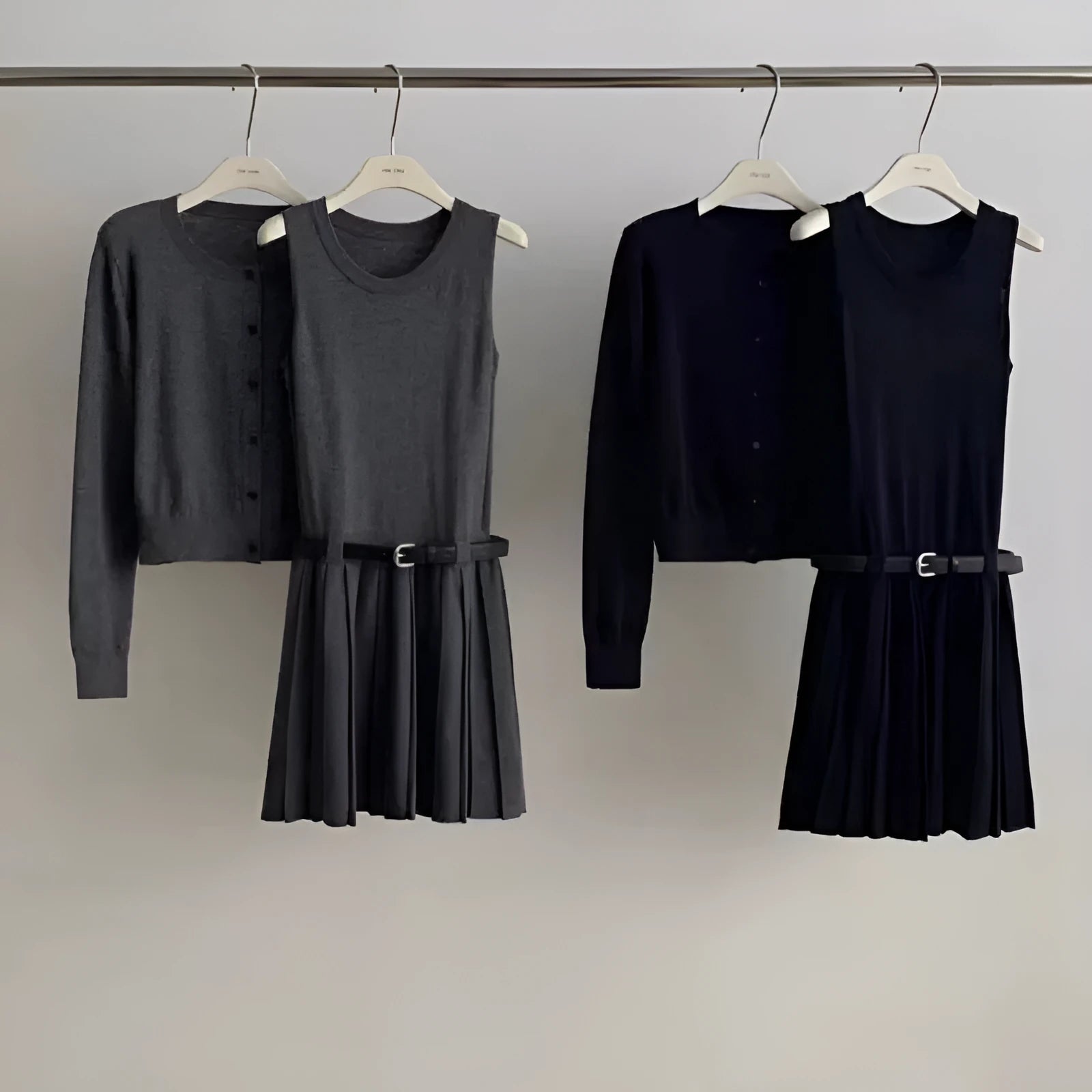 Women's grey knitted national style two-piece set with cardigan, pleated vest skirt, and belt.