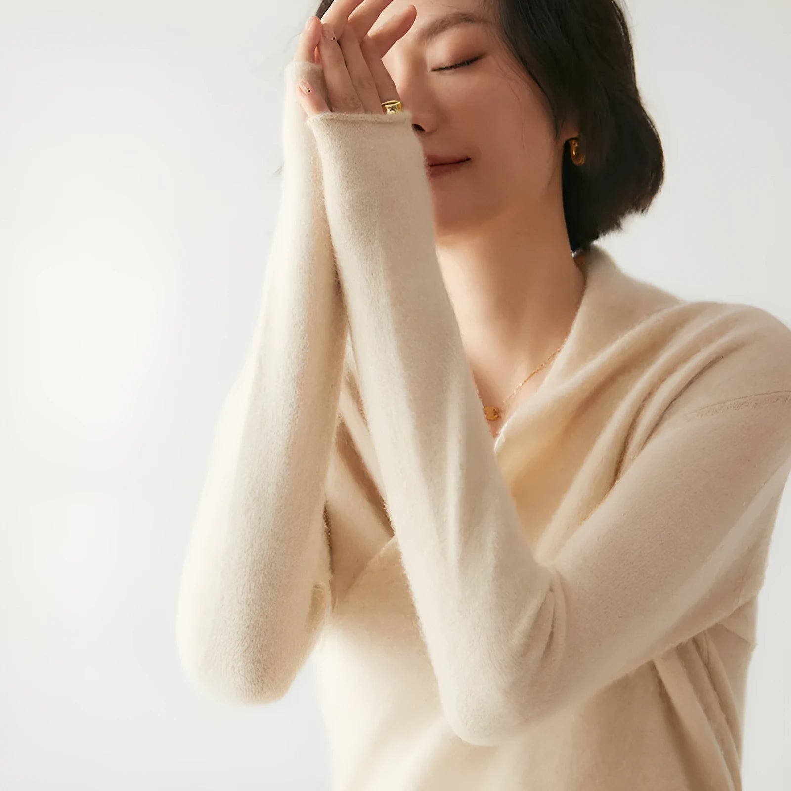 Women's solid colour cashmere V-neck cross sweater top with long sleeves in Elegant Camel, shown on a model.