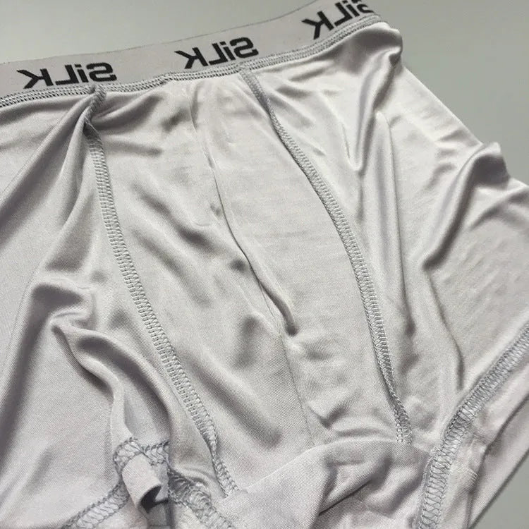 Men's loose fit silk shorts in navy blue, shown in a casual setting