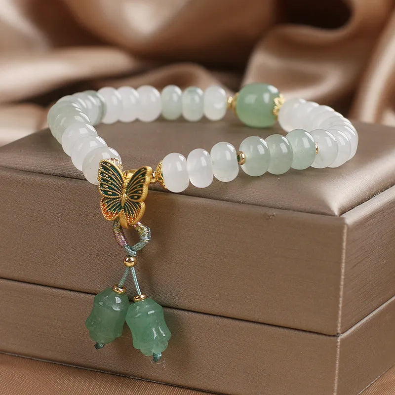 Green crystal women's bracelet with abacus beads, butterfly charm and tassel showing 17cm adjustable purity