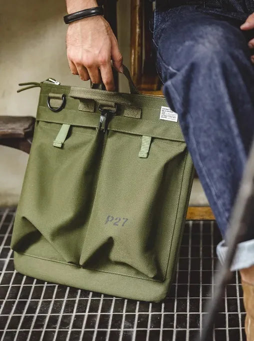 Marden Tooling Helmet canvas messenger crossbody bag in military green, showing vertical square shape and shoulder strap.