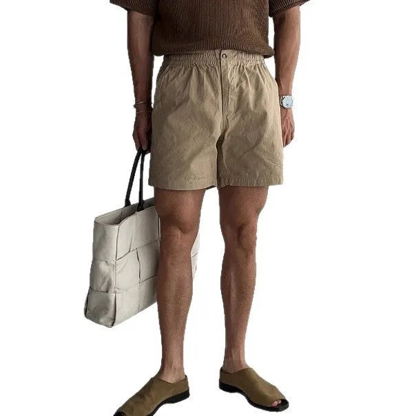 Men's loose-fit cotton sports shorts in khaki colour on a hanger.