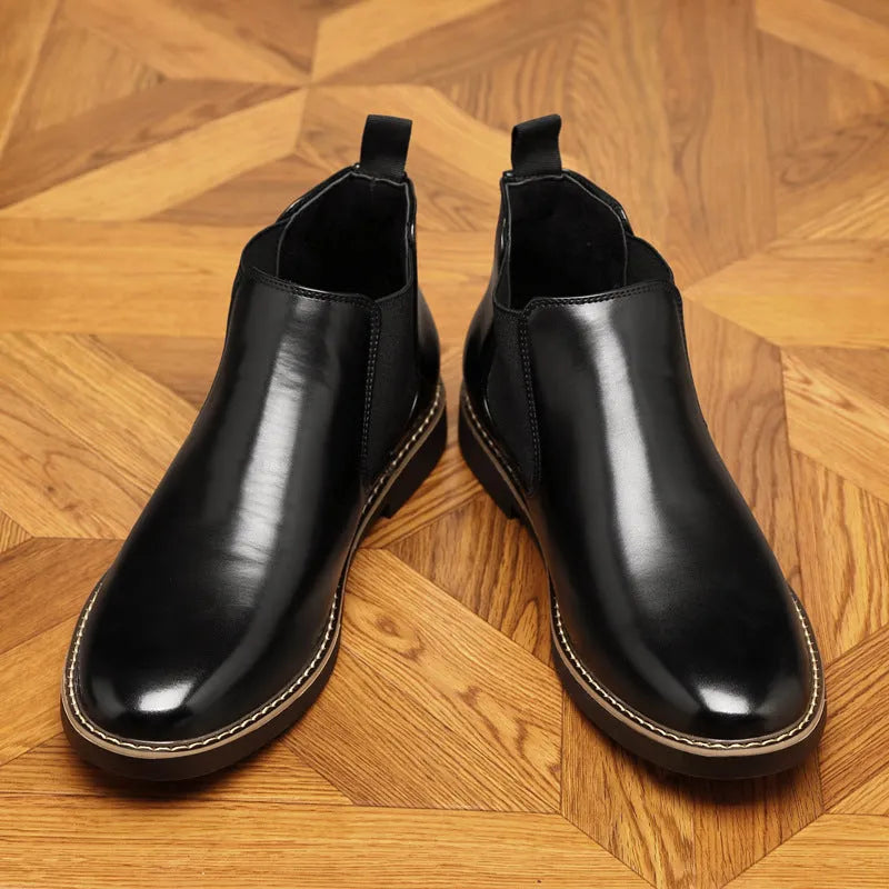 Men's black formal pointed-toe leather boots with a square heel and rubber sole on a plain background.