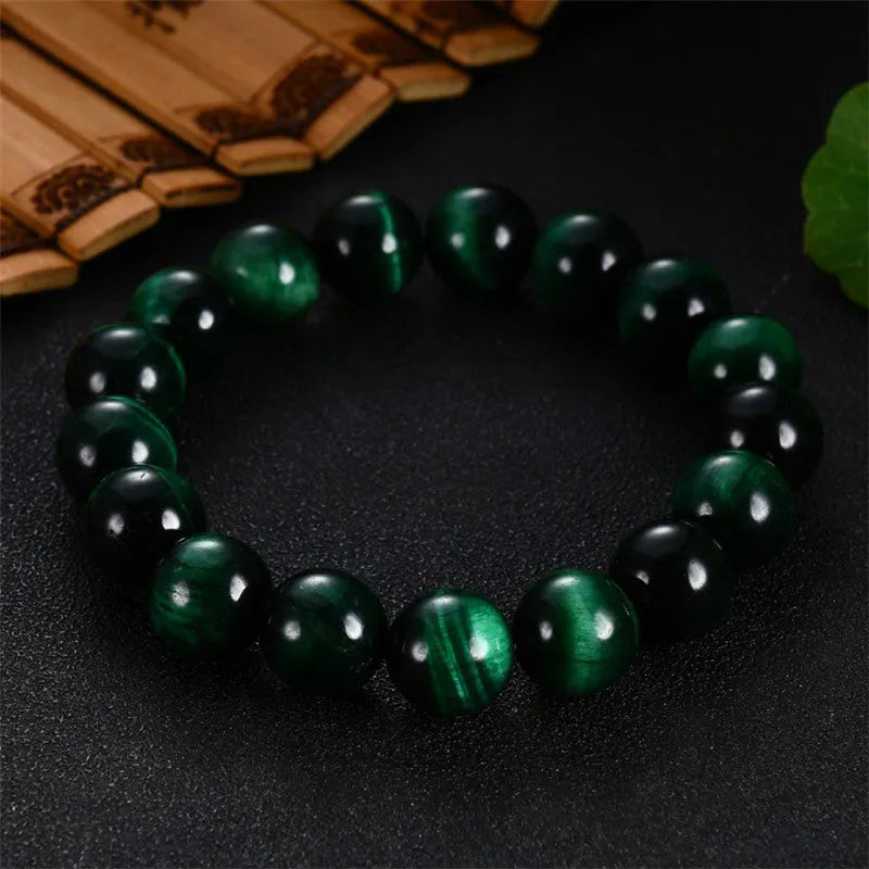 Green tiger eye stone bead bracelet with geometric polished beads on a wrist.