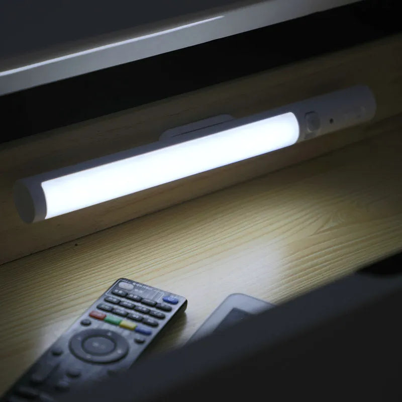 Slim white human body induction LED wall light with magnet back for under-cabinet or wardrobe installation.