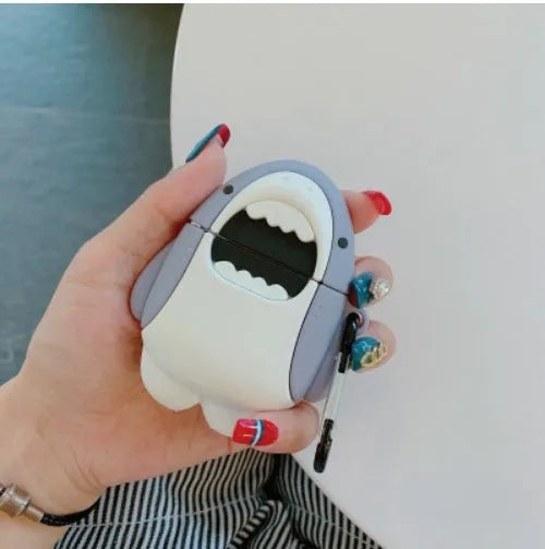Soft silicone cover with shark fin design on a white Apple Airpods 1 wireless earbud.
