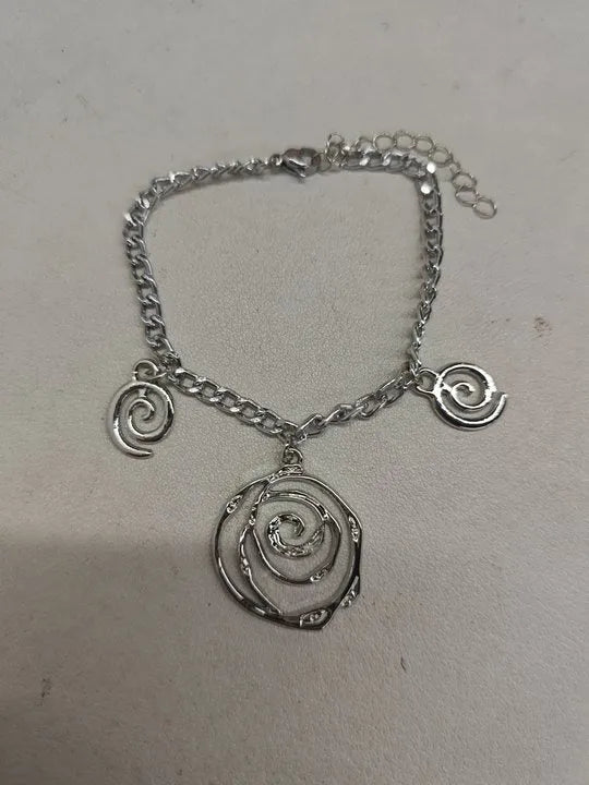 Gold tone donut spiral necklace, bracelet, and earrings set on a white background.