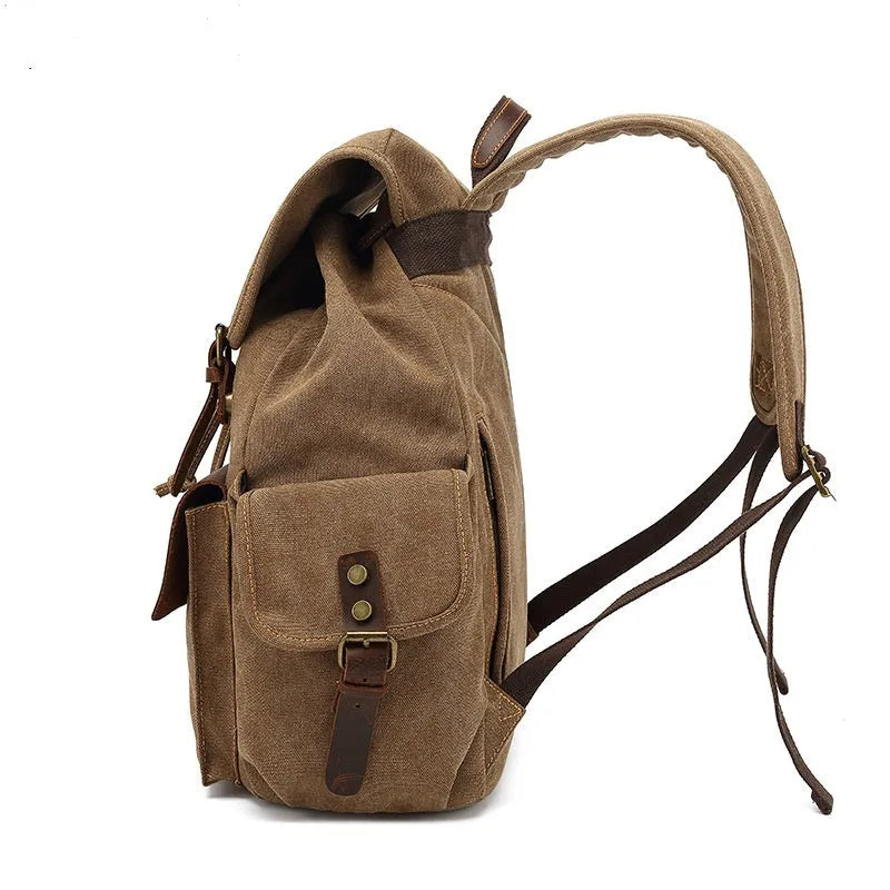 Retro military green canvas backpack with antique bronze hardware, shown with a laptop.