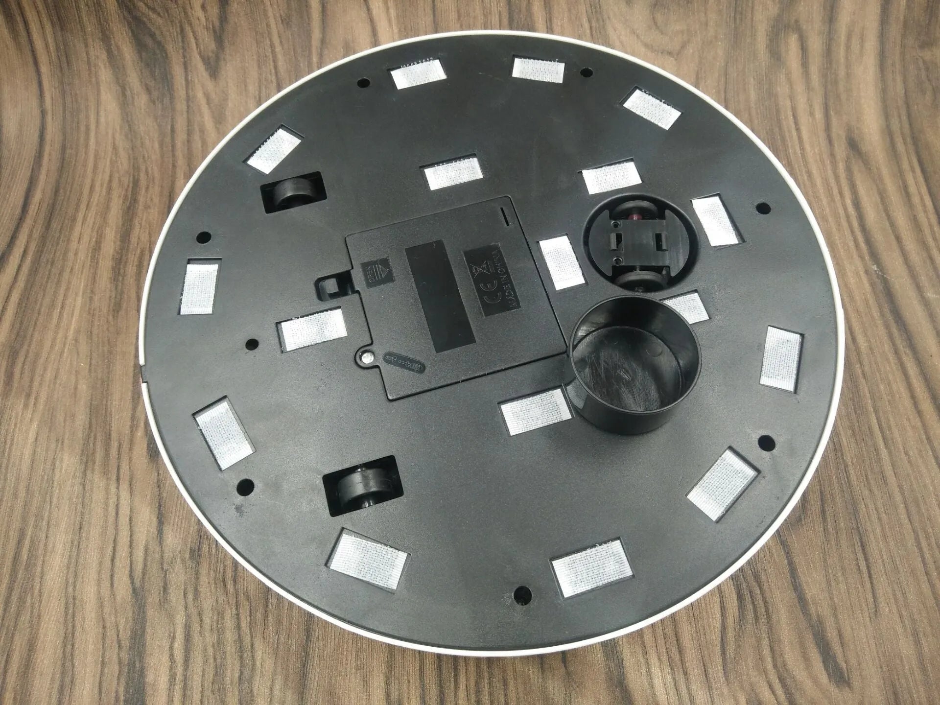 AC automatic robot vacuum cleaner in black or white on a hardwood floor