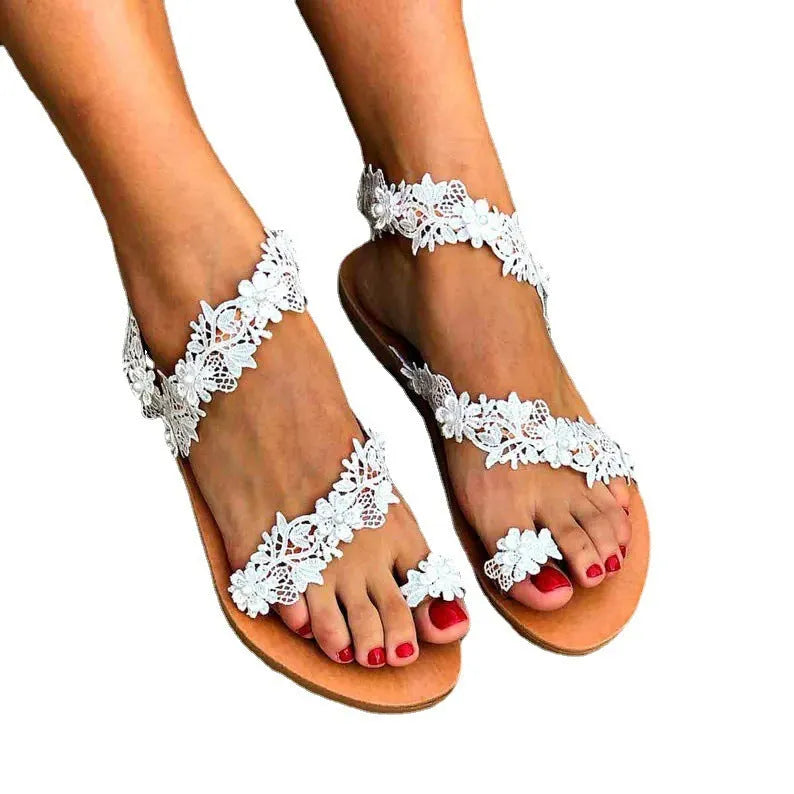 White women's flat sandals with rhinestone and flower decoration on the PU upper.