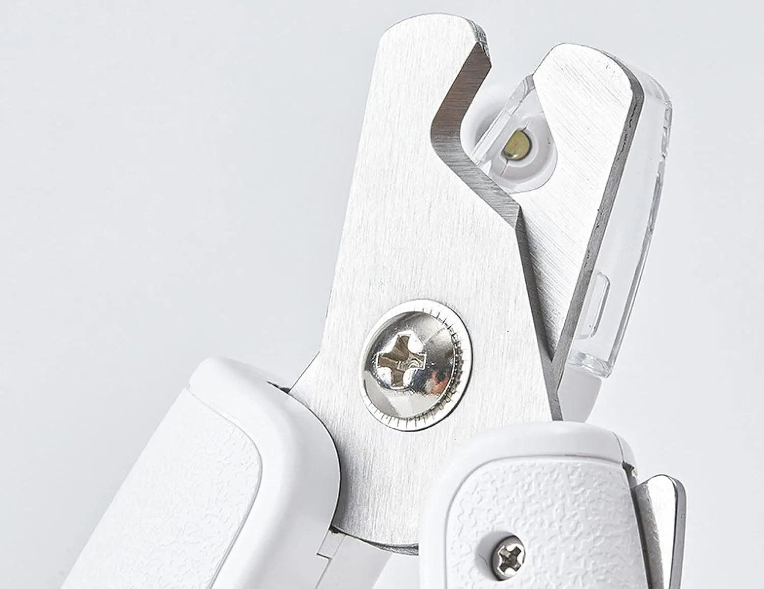 White pet nail clippers with LED light, transparent anti-splash guard, and leather-like handle on a table