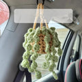 Green and white crochet knitted car plant decoration with rattan basin and white rope.