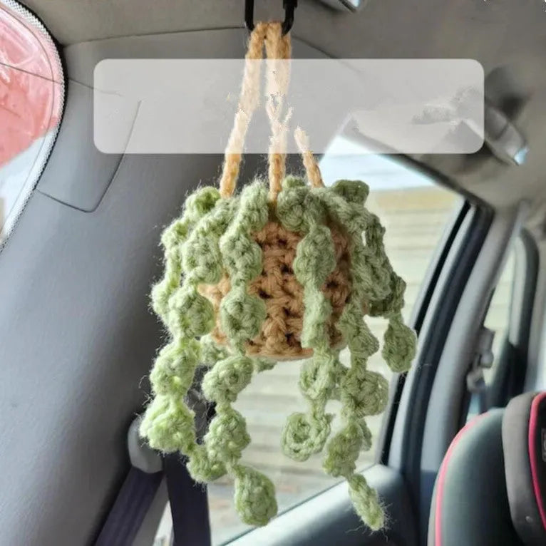 Green and white crochet knitted car plant decoration with rattan basin and white rope.