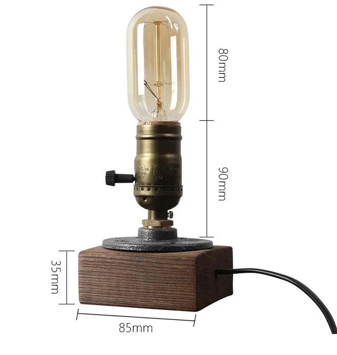 Industrial style wood and iron pipe table lamp with E26 socket on a wooden surface.