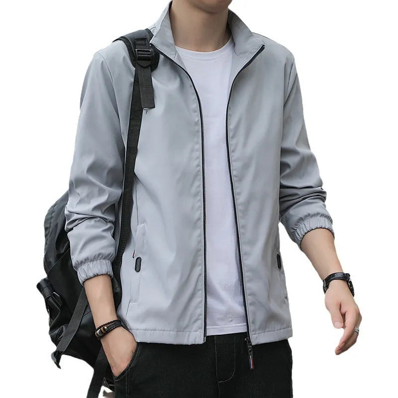 Man wearing a loose-fit Korean-style casual jacket in a dark colour, showing the lapel design, zip, and pockets.