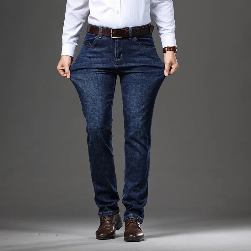 Men's black stretch denim jeans showing loose straight-leg fit with mid waist and zip fly detail