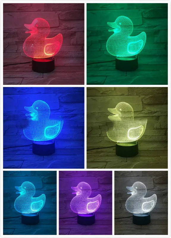 Little yellow duck 3D table night light showing seven colour options on a desk next to its black remote control.