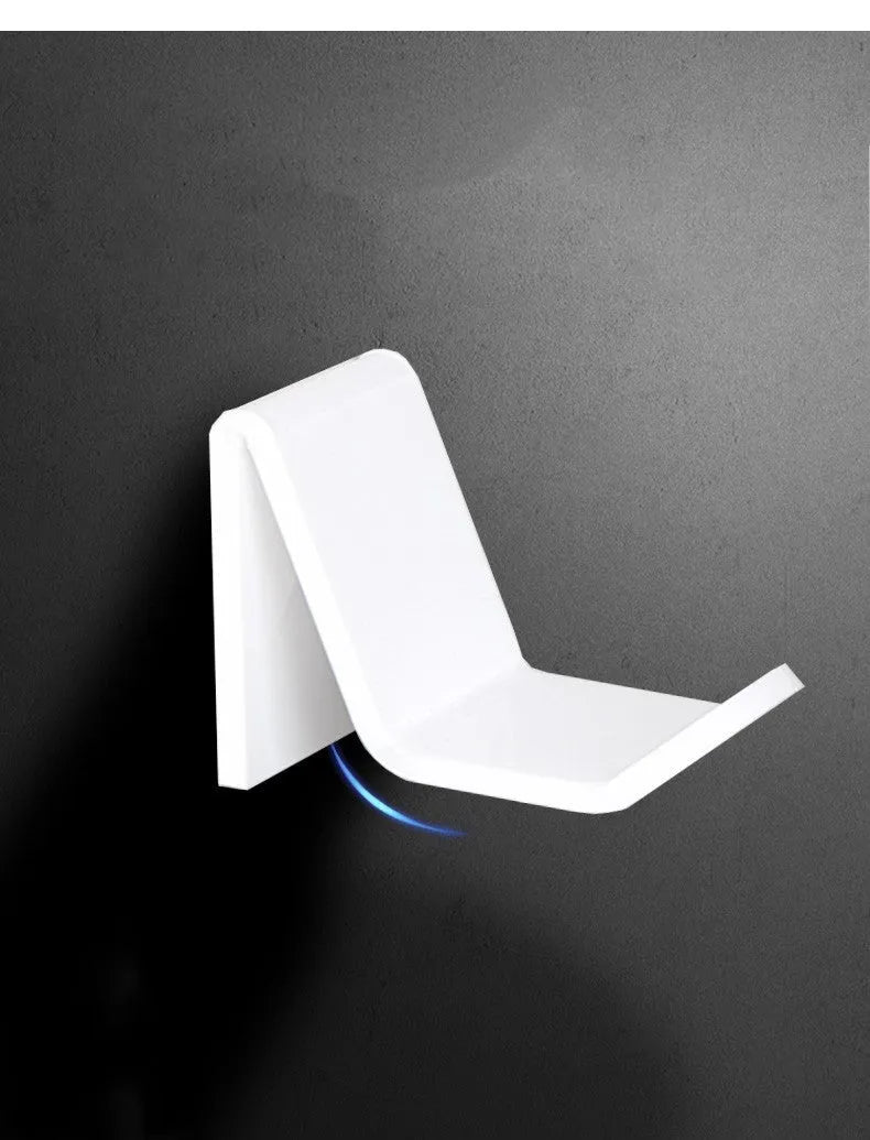 Universal plastic game controller bracket mounted on a wall in a choice of black, white, or transparent.