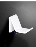 Universal plastic game controller bracket mounted on a wall in a choice of black, white, or transparent.