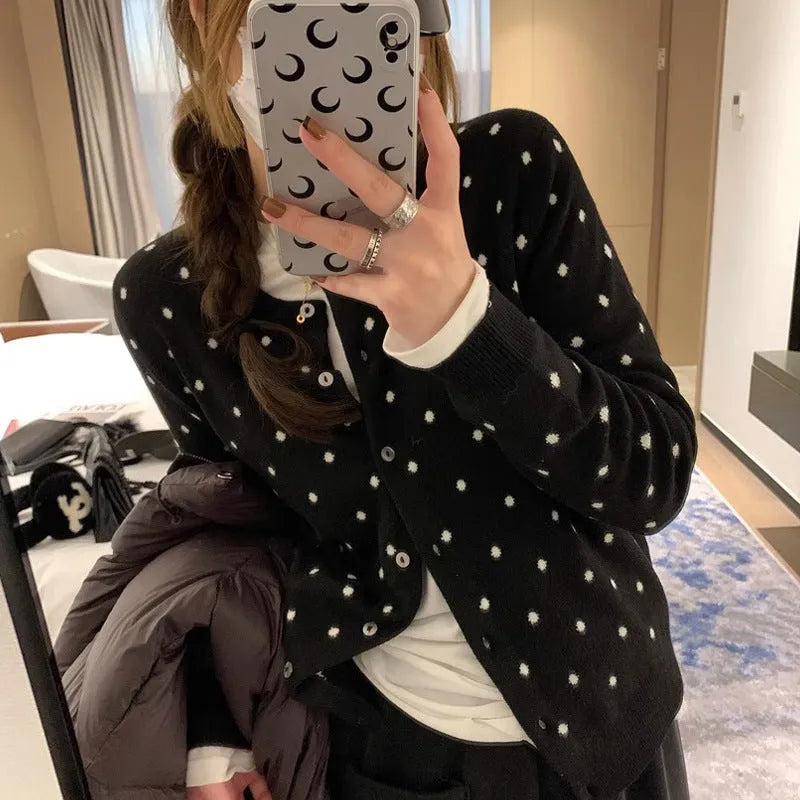 Women's grey loose-fit knitted cardigan with long sleeves on a hanger.