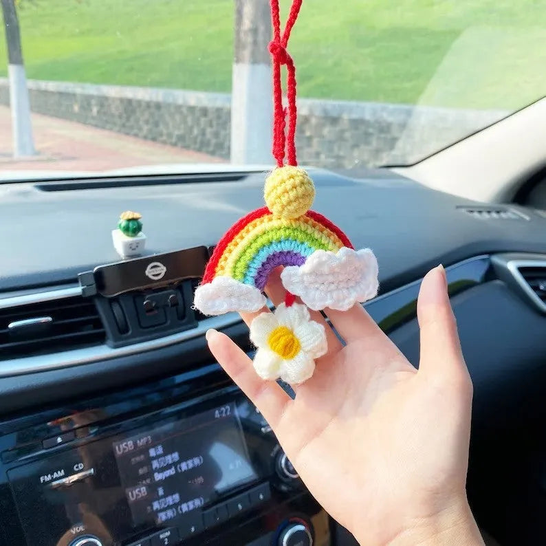 Handmade crocheted wool car pendant shaped like a cartoon avocado with a rainbow flower decoration.