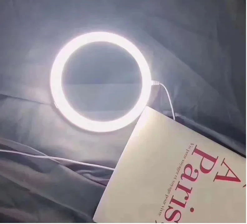 White foldable LED vanity mirror with a ring light, shown open on a table.