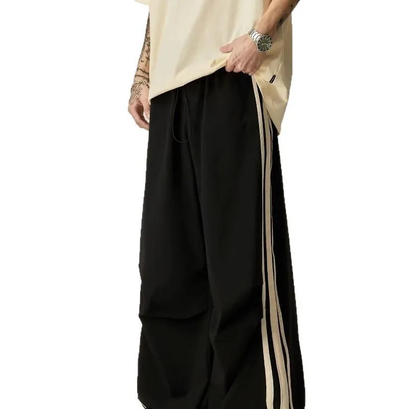Man wearing black high-waist wide-leg climbing trousers in a casual setting