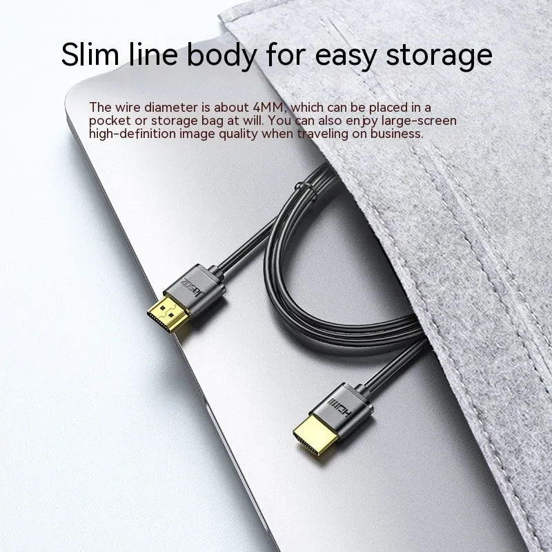 Thin flexible HDMI cable with gold-plated connectors on a white background.