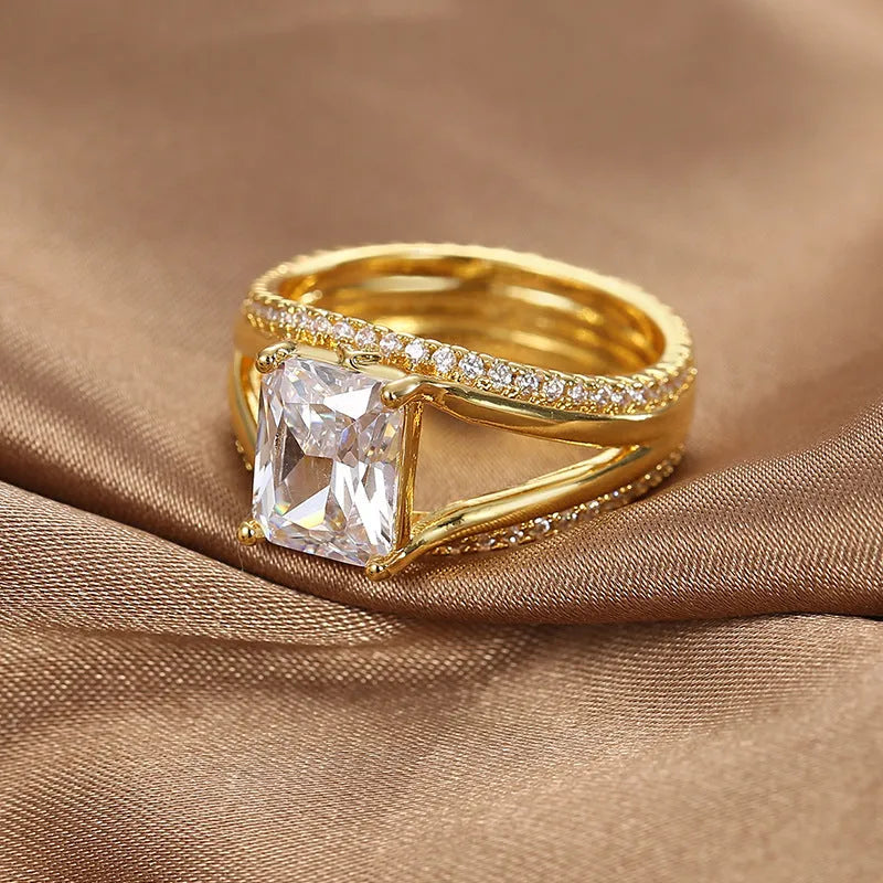 Geometric gold electroplated copper ring for women with a square zircon, shown in sizes 6 to 9.