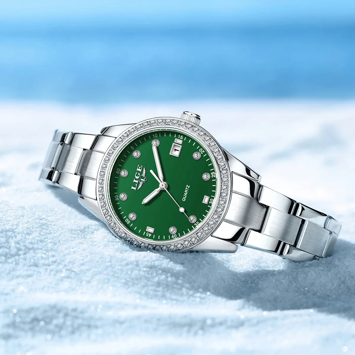 Silver-tone women's fashion watch with round dial, diamond bezel, and luminous hands on a wrist.