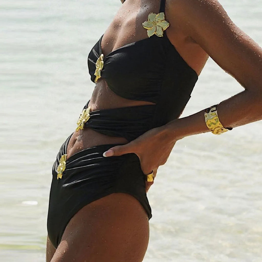 Adult woman wearing a solid colour one-piece swimsuit with a hollow-out tube top and a separate matching short skirt.