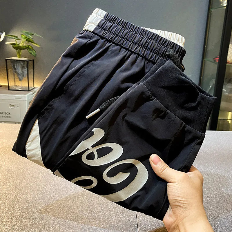 Men's black cropped ankle band trousers in ultra-thin ice silk cotton material showing casual styling