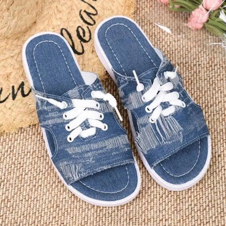 Blue Roman style women's flat canvas slippers with cloth lining, shown from the side.
