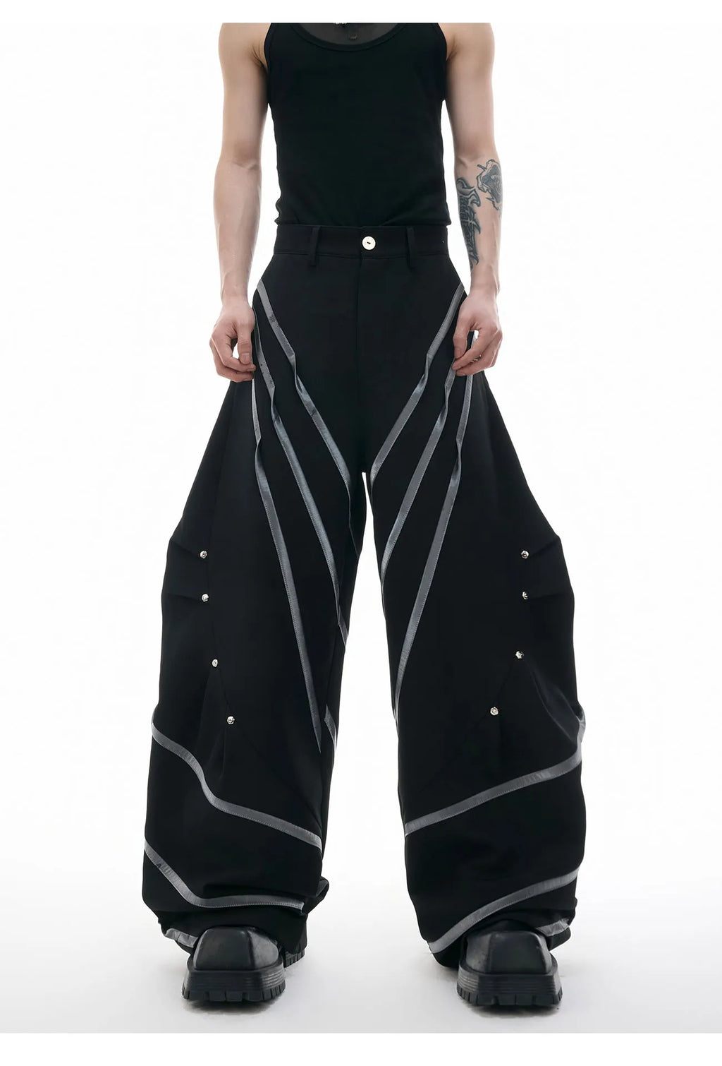 Men's polyester trousers with metal rivet accents and pleated detailing on three-dimensional cutting construction