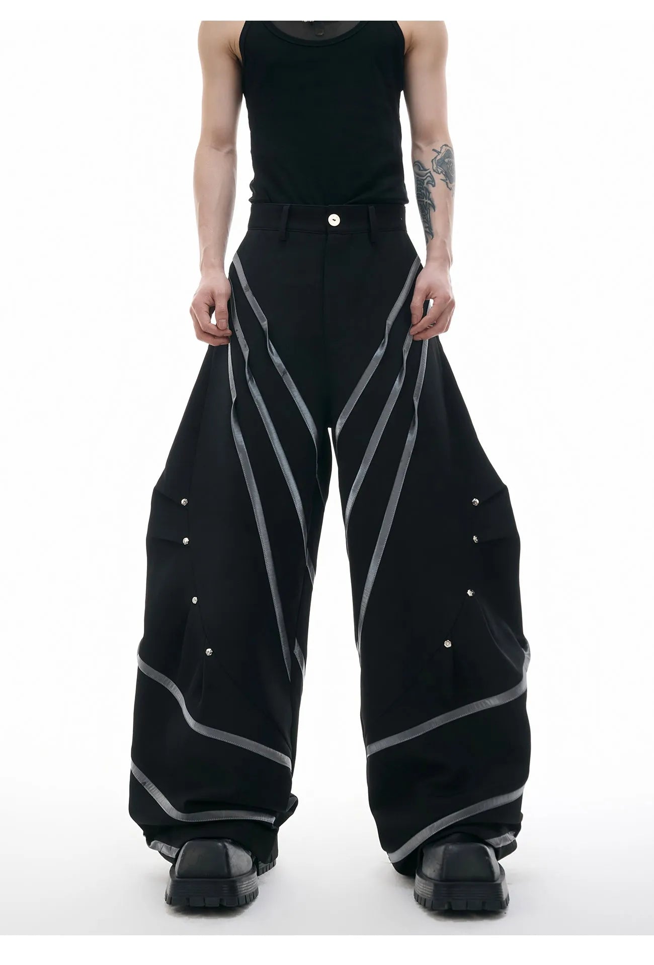Men's polyester trousers with metal rivet accents and pleated detailing on three-dimensional cutting construction
