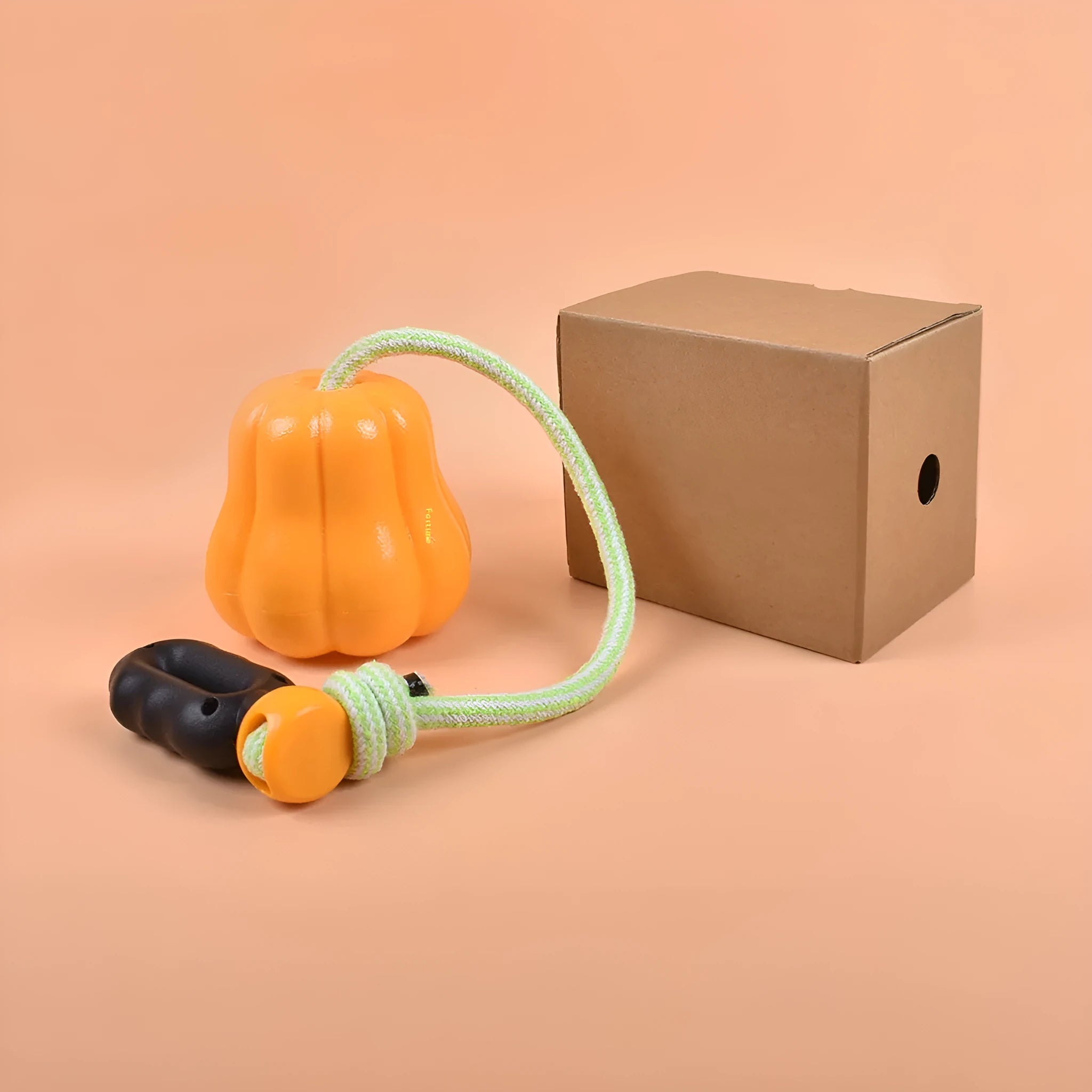 Orange plastic molar-shaped dog chew toy with a rope attached for tug-of-war play.