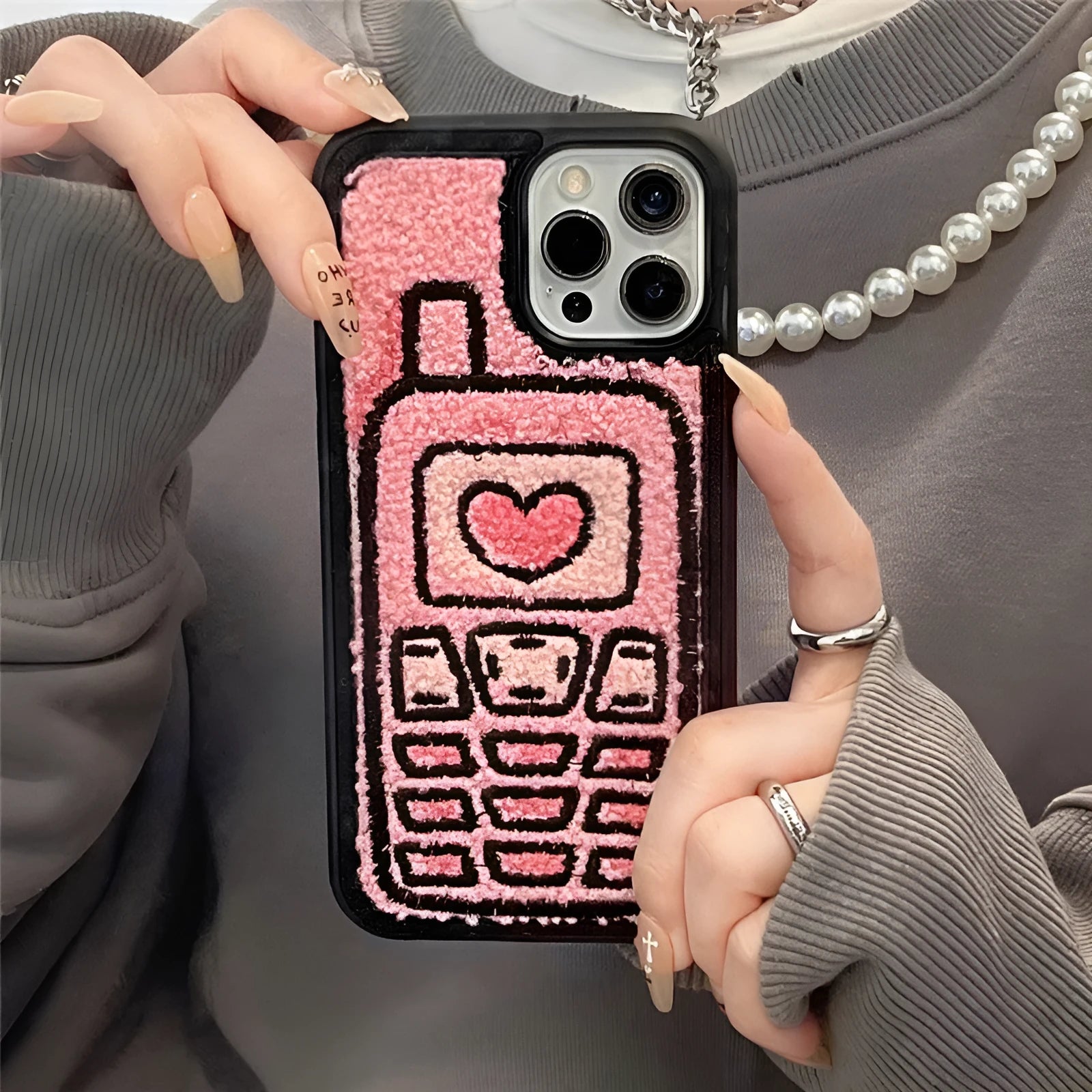 Pink iPhone back cover with a raised embroidered towel pattern design.