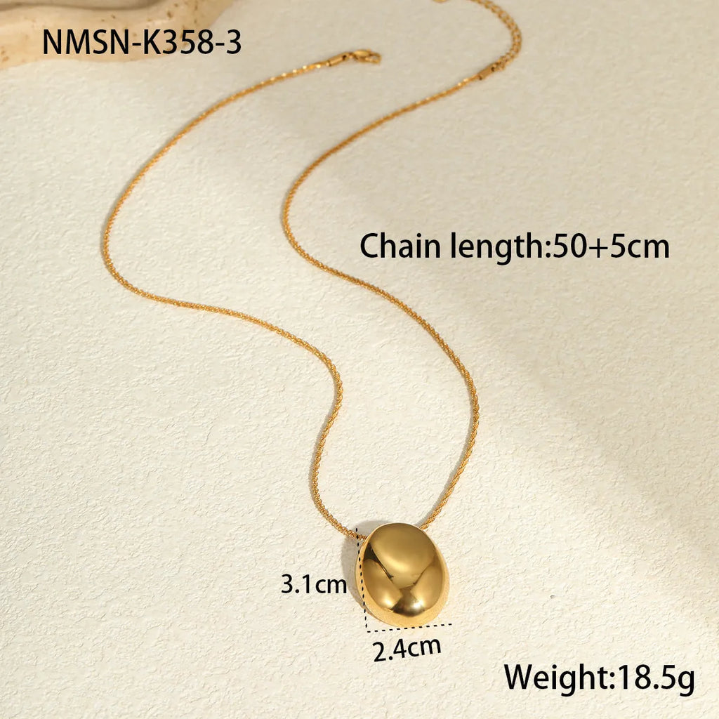 Gold geometric pendant necklace on adjustable chain against white background