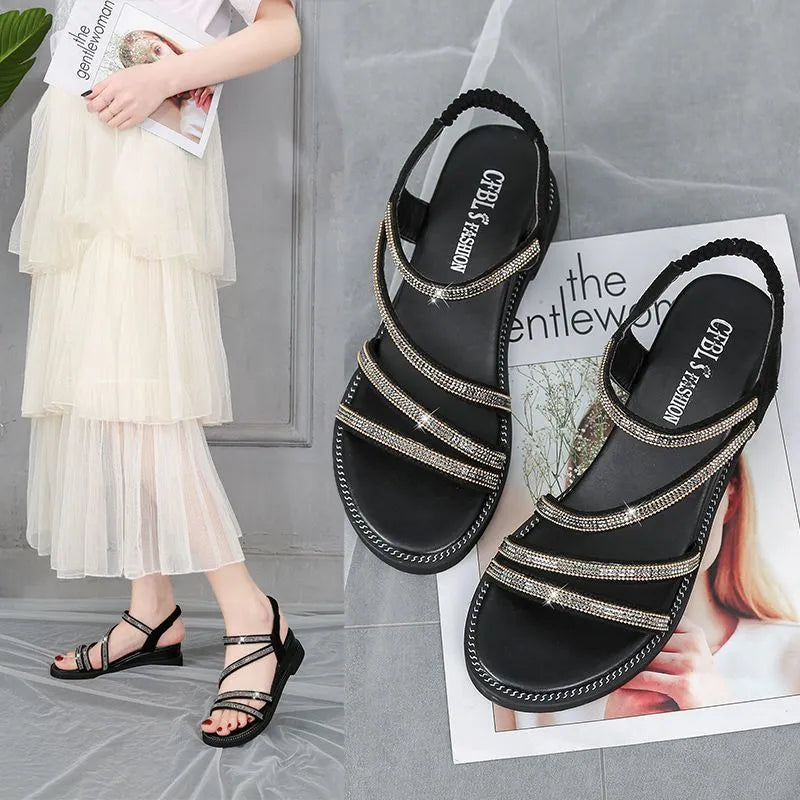 Women's silver flat sandals with round toe, rhinestone decoration, and elastic band on a non-slip rubber sole.