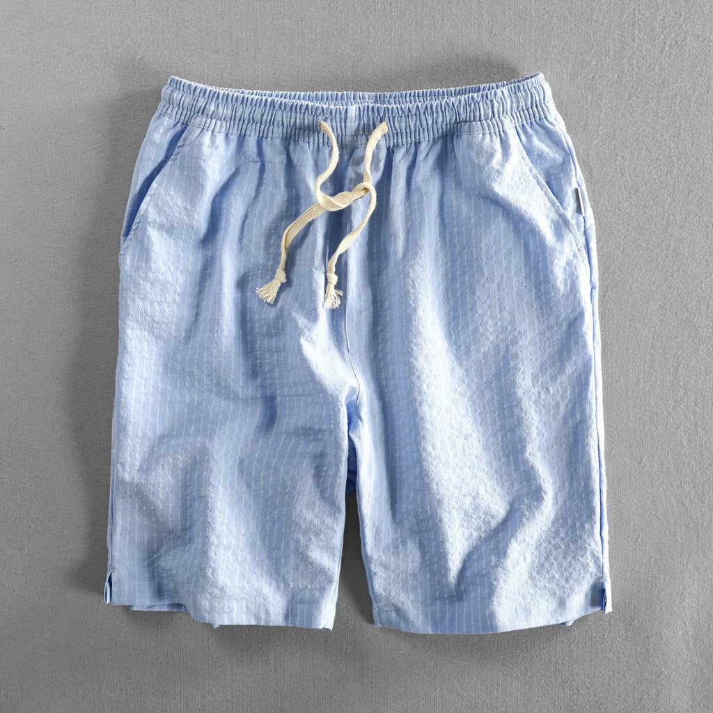 Man wearing black and white striped casual cotton shorts with a loose straight fit.