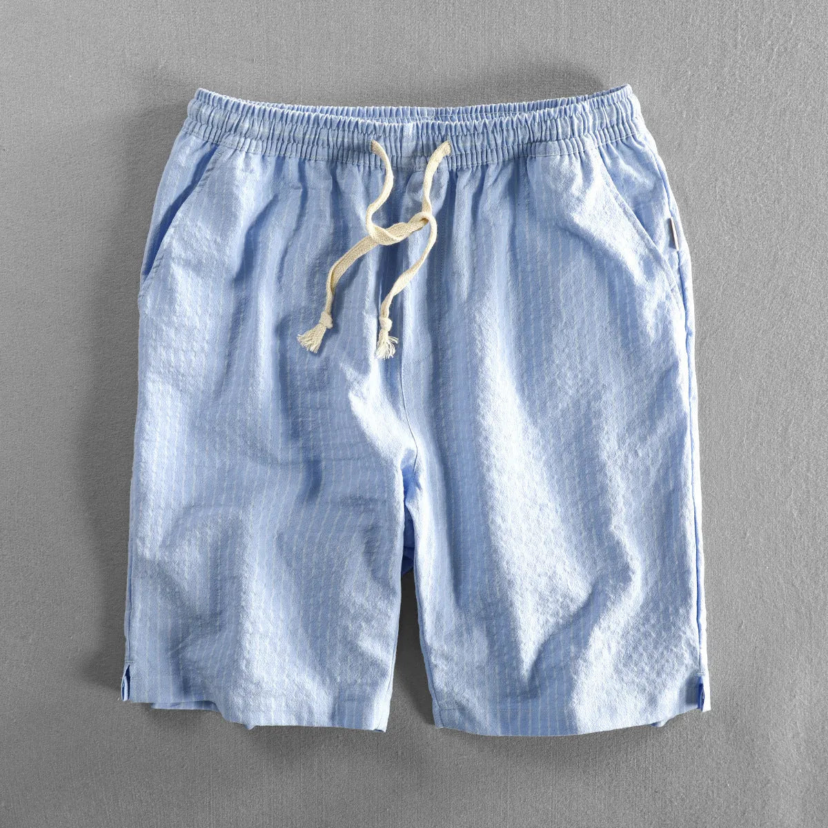 Man wearing black and white striped casual cotton shorts with a loose straight fit.
