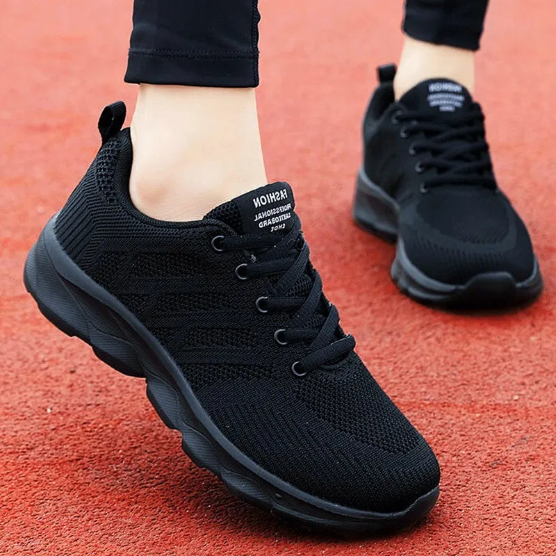Women's white breathable mesh lace-up shoes with a low heel on a plain background.
