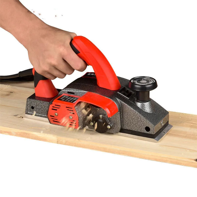 Red electric wood planer with 82mm cutting width and aluminium shell construction
