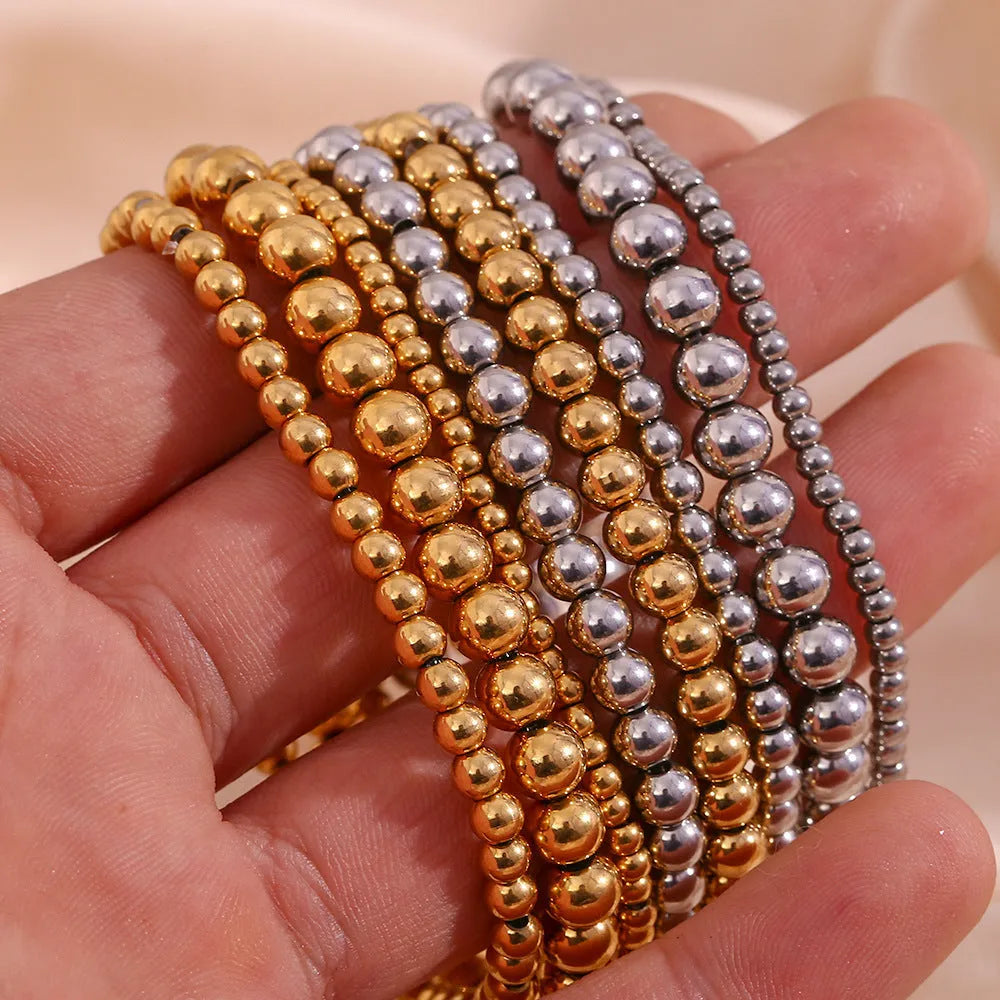 Stainless steel plated elastic bead bracelet with round geometric beads in gold finish