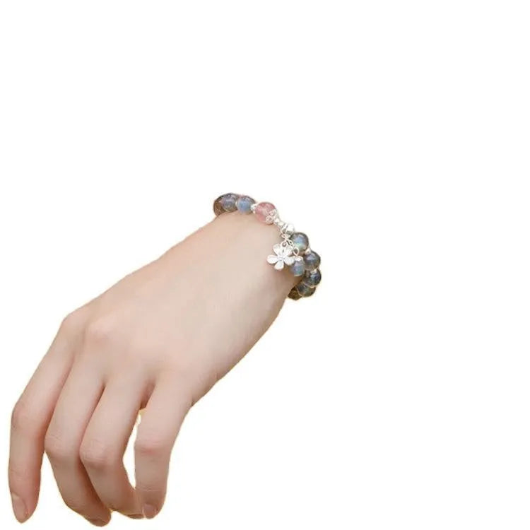 Silver grey women's bracelet with honeysuckle pattern, moonlight crystals, and a small zodiac charm.
