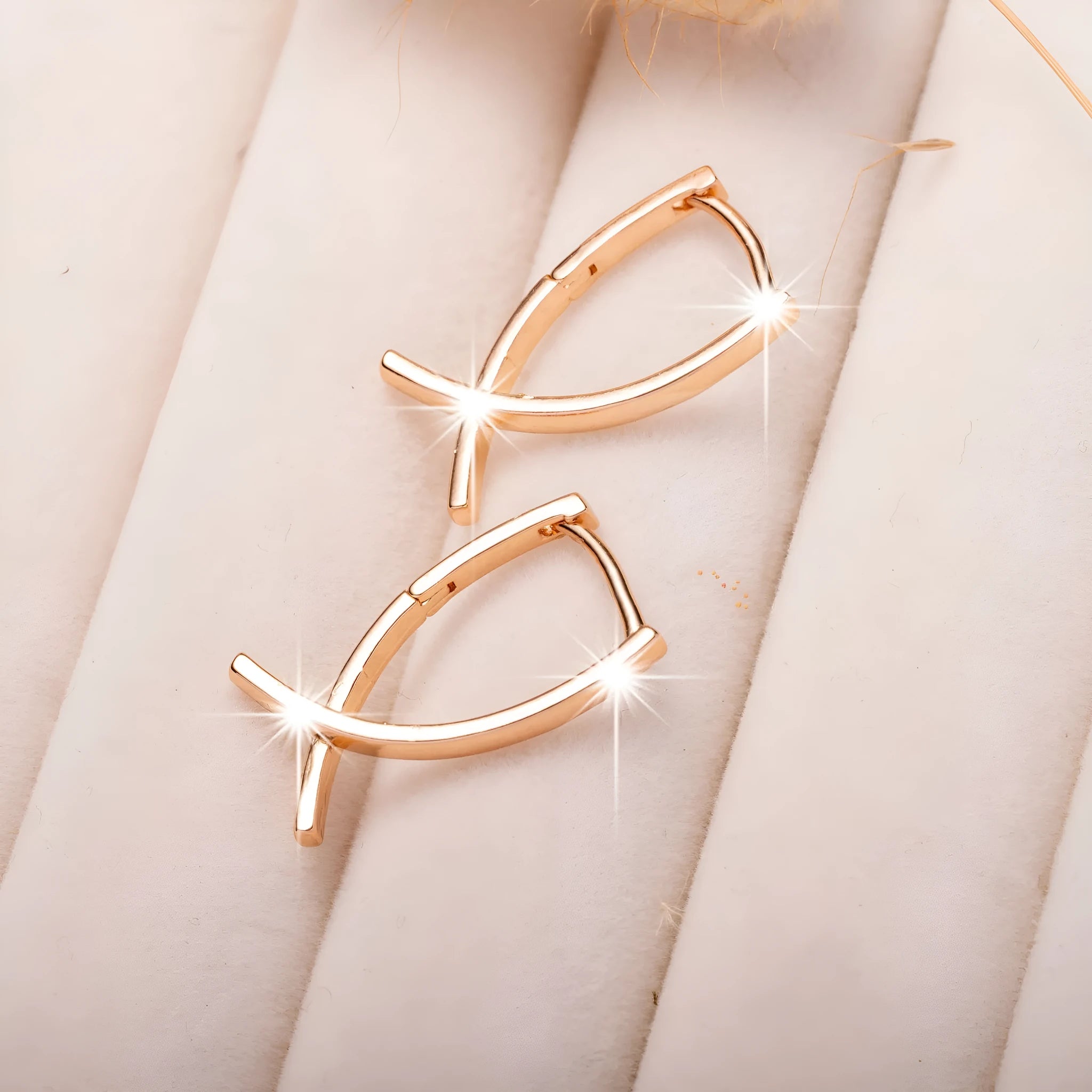 Rose gold cross shaped fashion earrings made from copper on a white background