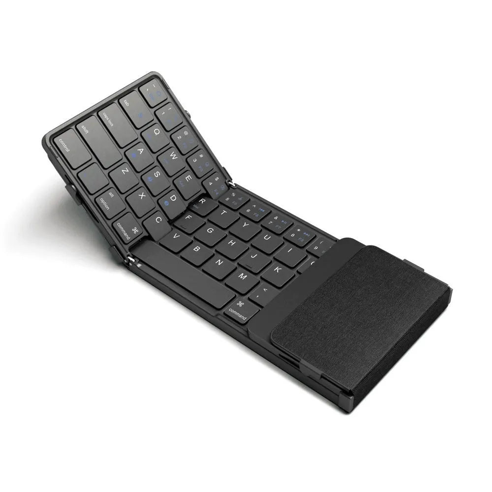 Black folding Bluetooth keyboard shown in open position next to mobile phone