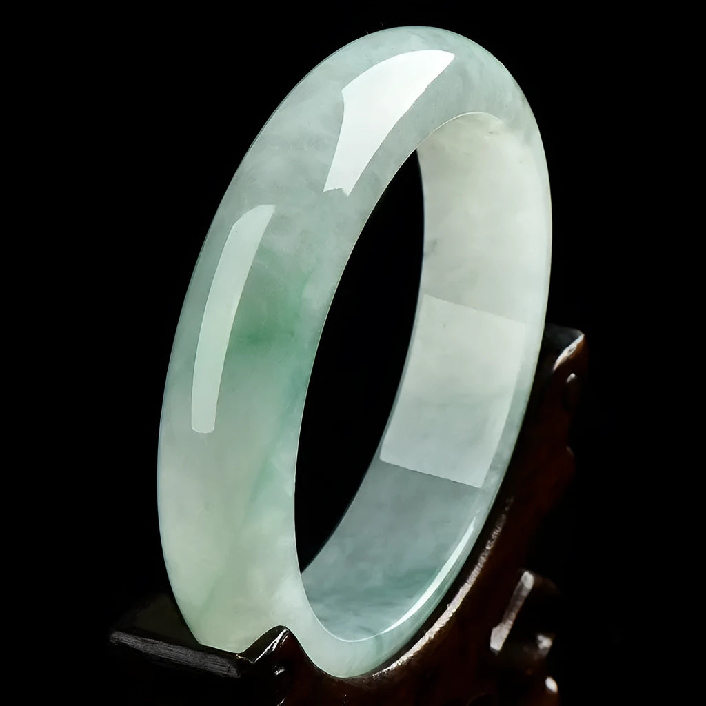 Light green jade bracelet on a white background, showing natural stone texture.